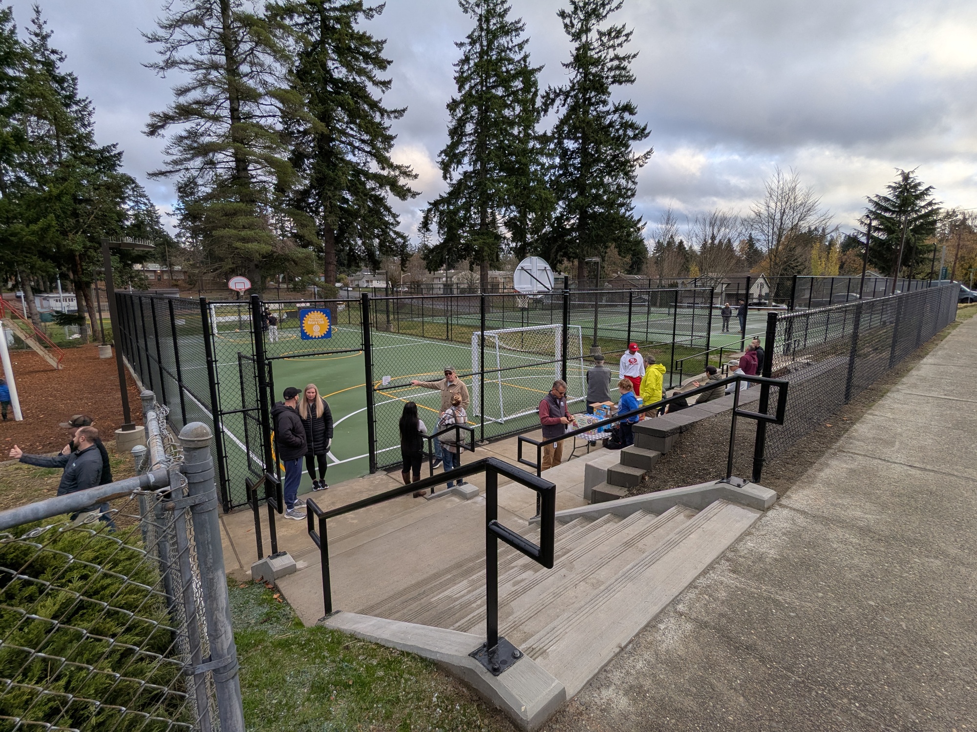 Community members gather at the new pickleball courts to celebrate on opening day