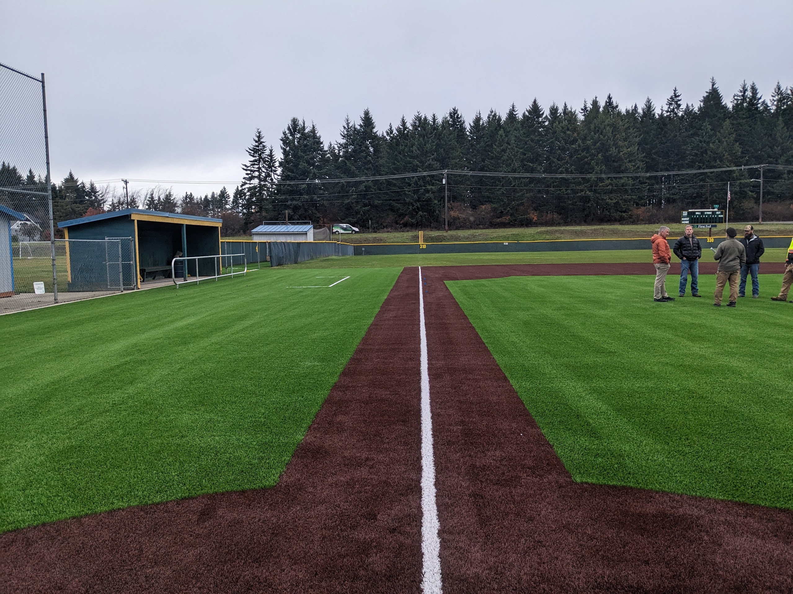 Project officials converse on the newly installed synthetic infield