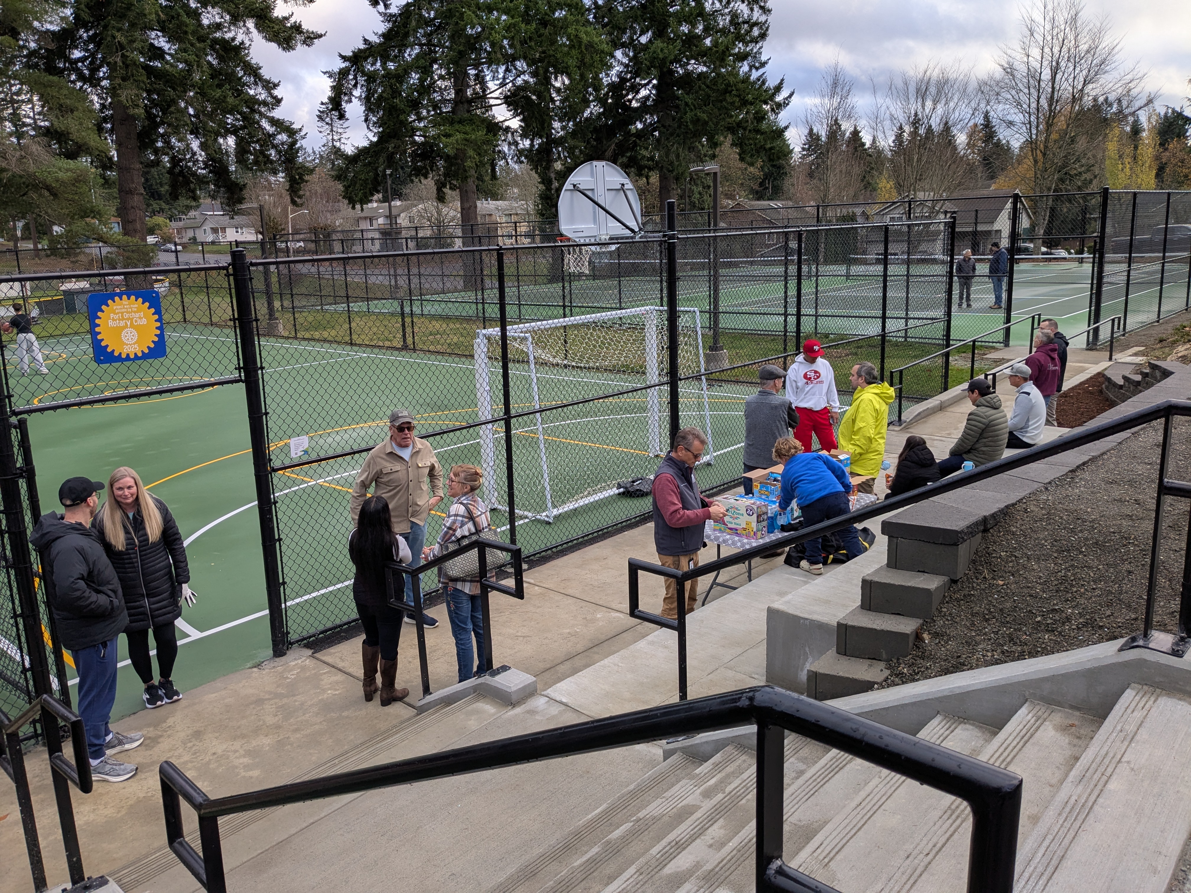 Community members gather at the new pickleball courts to celebrate on opening day