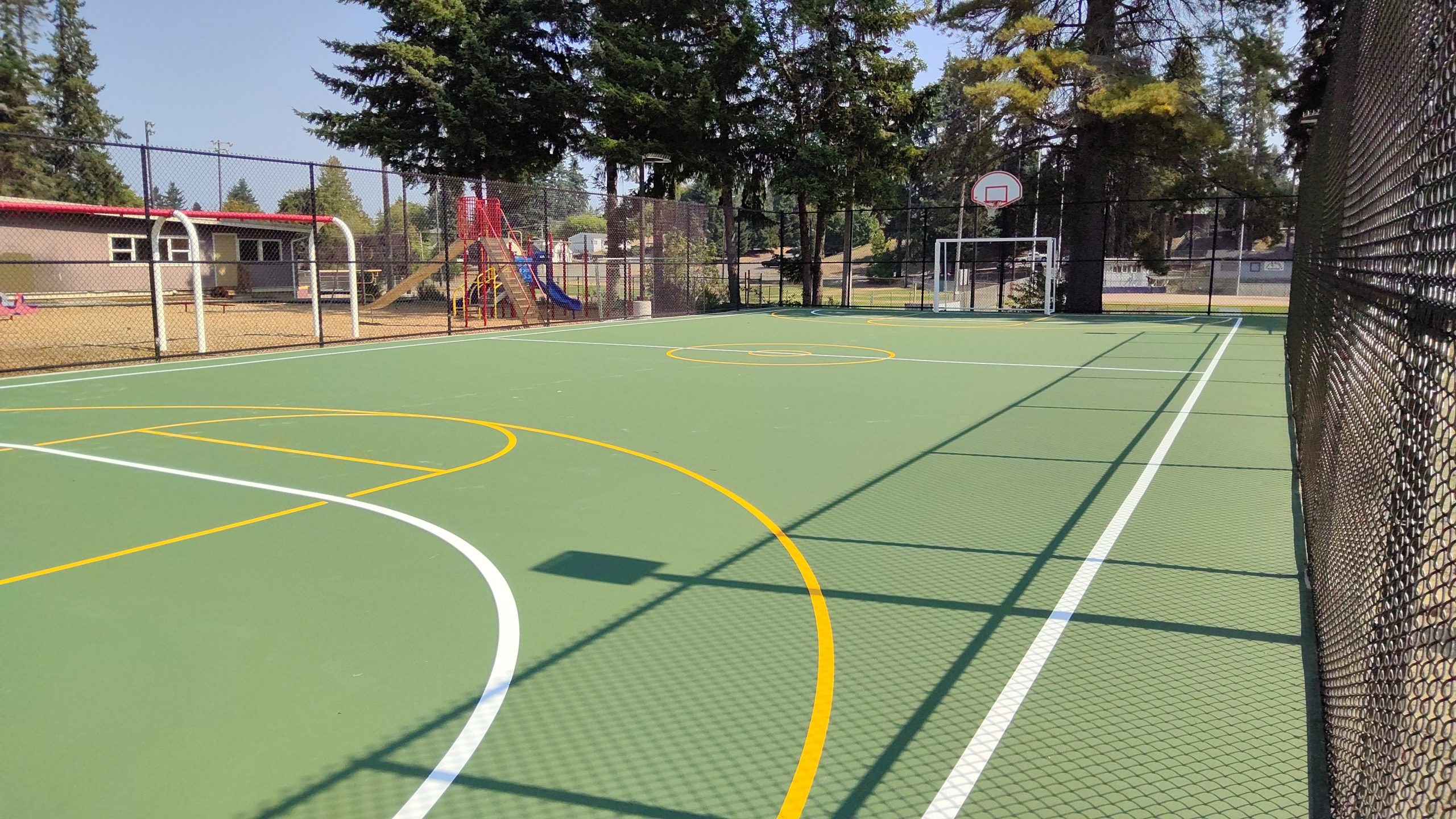 One court include line markings for different sports as well as basketball hoops and futsal goals