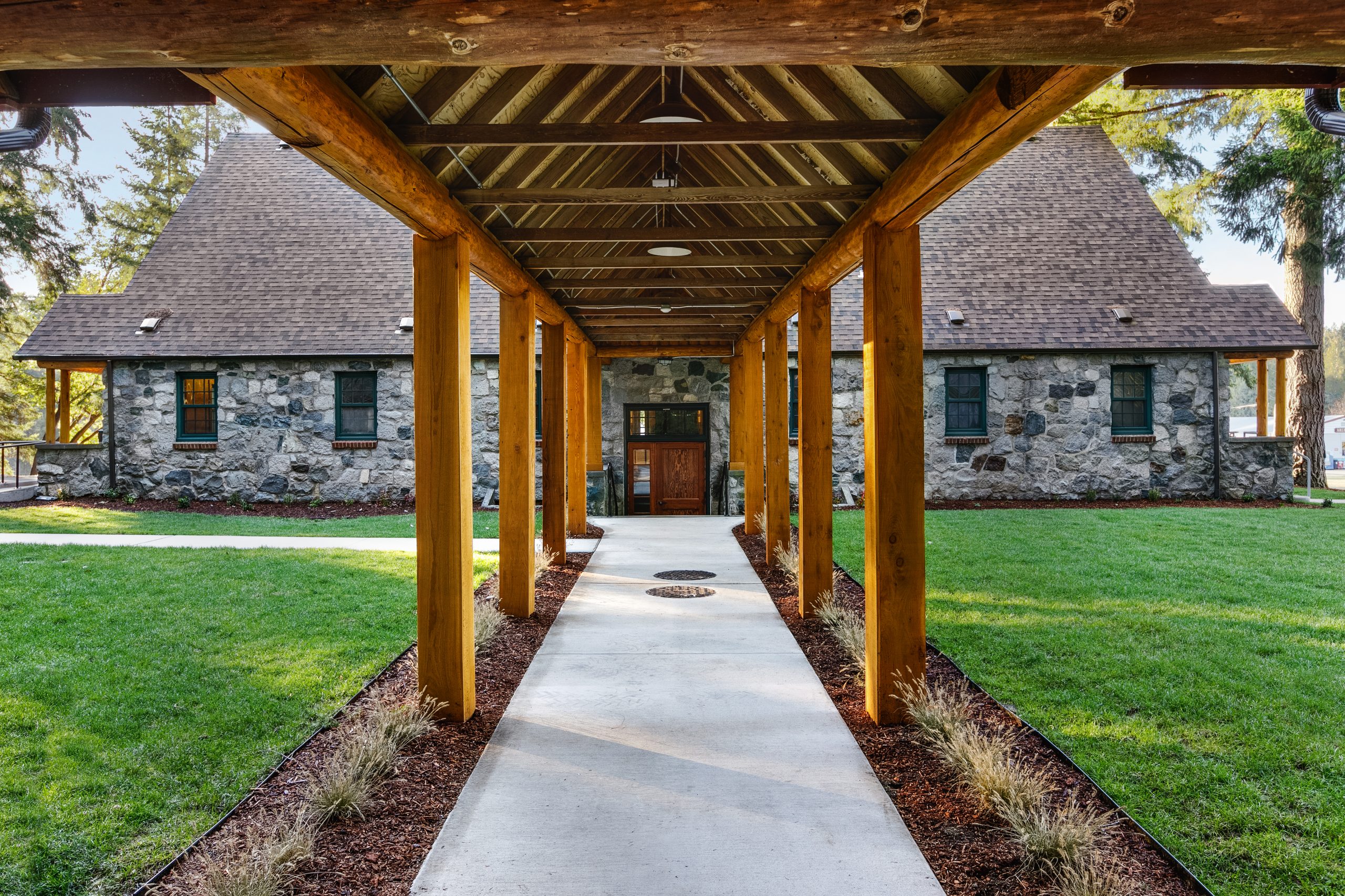 The roofed path connecting the main structure and pavilion is flanked by new planting beds of each side of the path