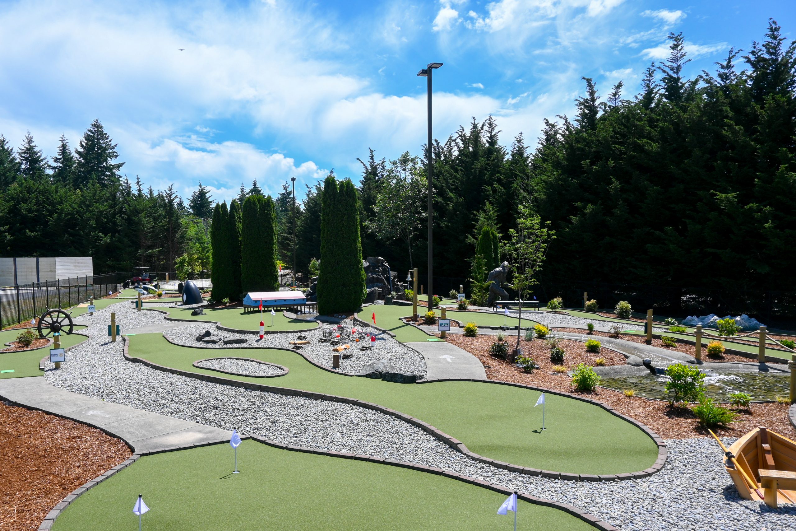 Perspective looking down the length of the course which is framed against the backdrop of a tall evergreen hedge