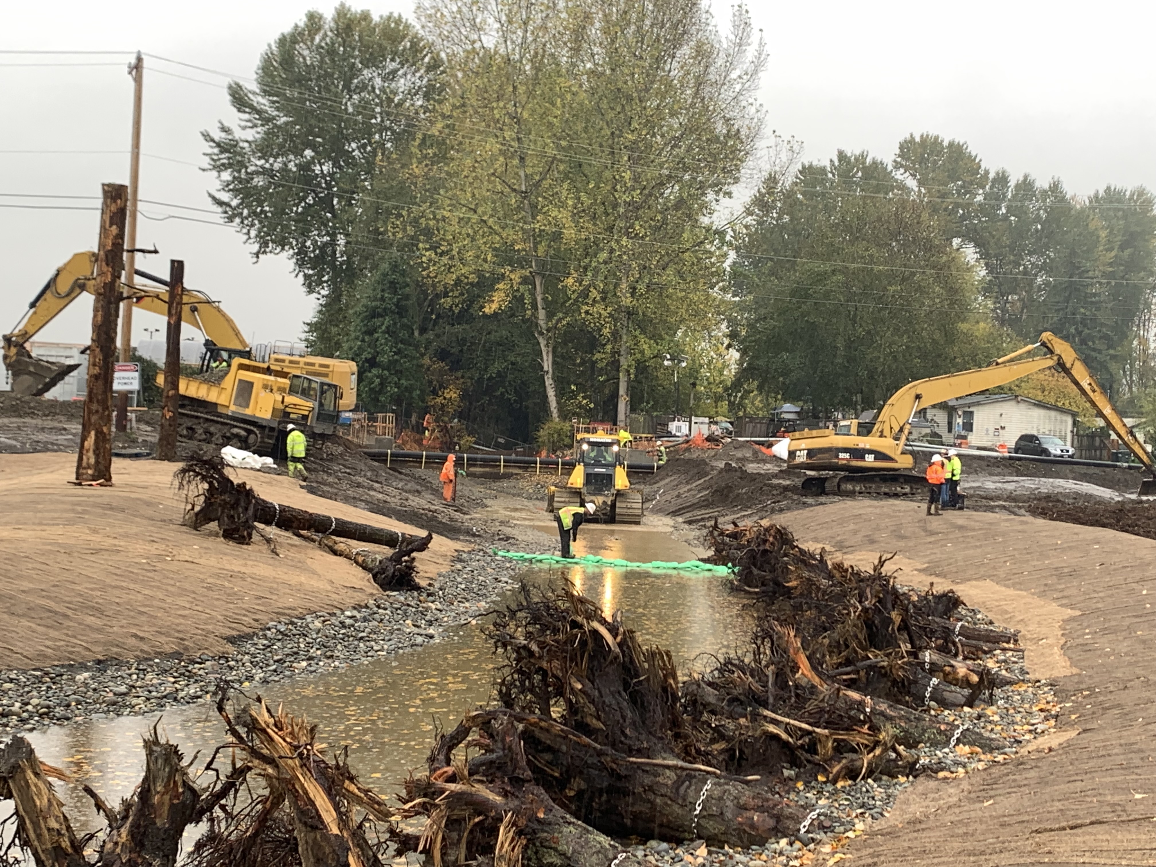 Stream channel under construction with habitat debris set into the stream bank.