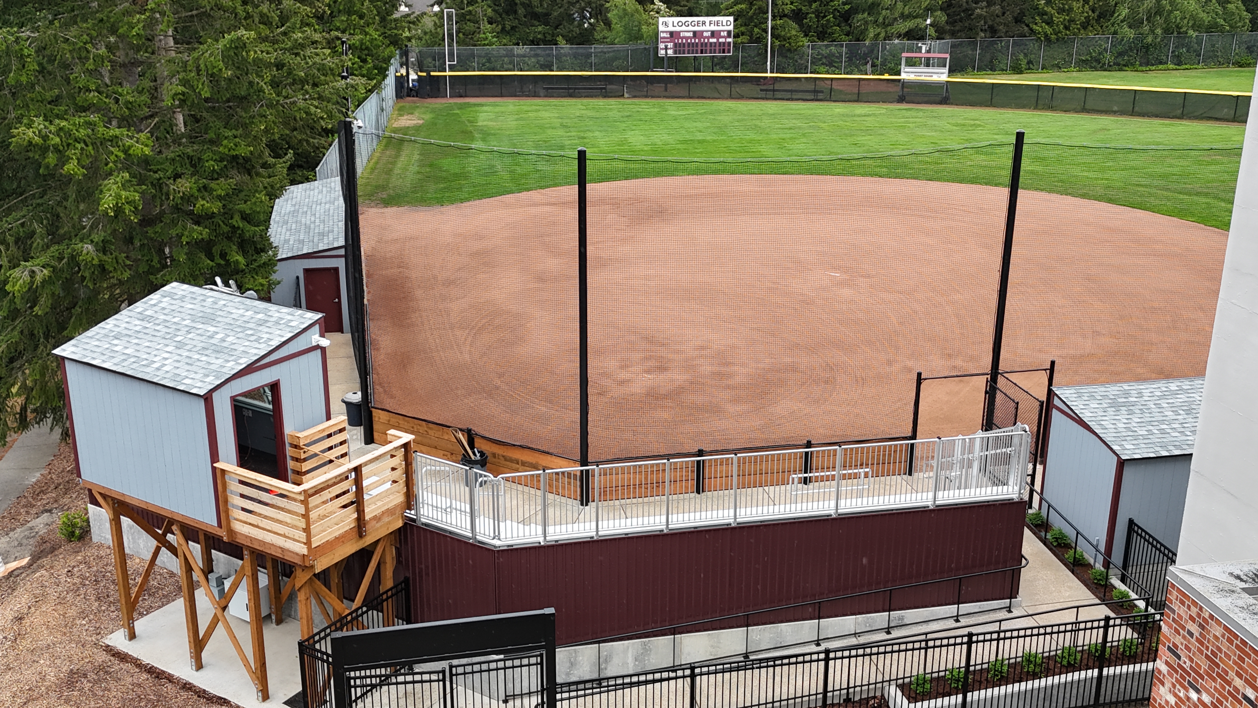 A newly constructed pressbox and pedestrian ramp wraps around bleachers behind the infield backstop